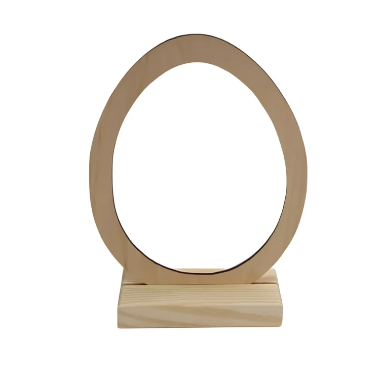 Drewniana dekoracja w rozmiarze S o wysokości 22 cm. Jajowaty drewniany pierścień o gładkim wykończeniu, ustawiony pionowo na prostokątnej podstawie.