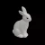 Minimalistyczna figurka beżowego zająca w pozycji siedzącej, z prostymi liniami, matową fakturą i delikatnie zaznaczonymi oczami, idealna jako dekoracja wnętrza.