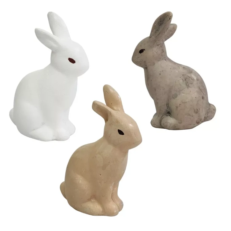 Trzy niewielkie figurki gipsowych zająców w kolorach białym, beżowym i szarym, ustawione obok siebie w pozycji siedzącej, o minimalistycznym i matowym wykończeniu dekoracyjnym.