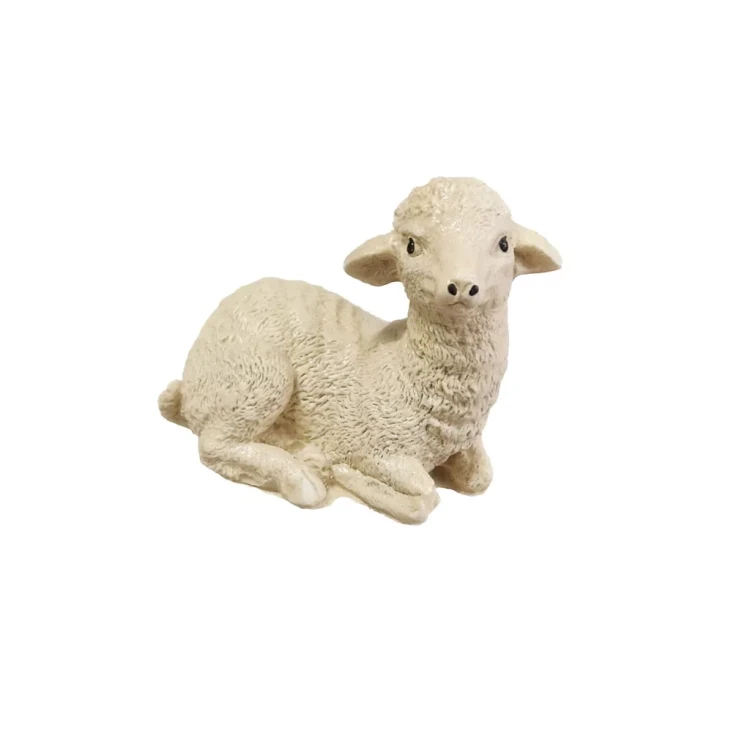 Beżowa figurka leżącego barana z wyraźną, wełnistą fakturą, delikatnymi rysami pyszczka i czarnymi oczami, przedstawiona w spokojnej, naturalnej pozie.