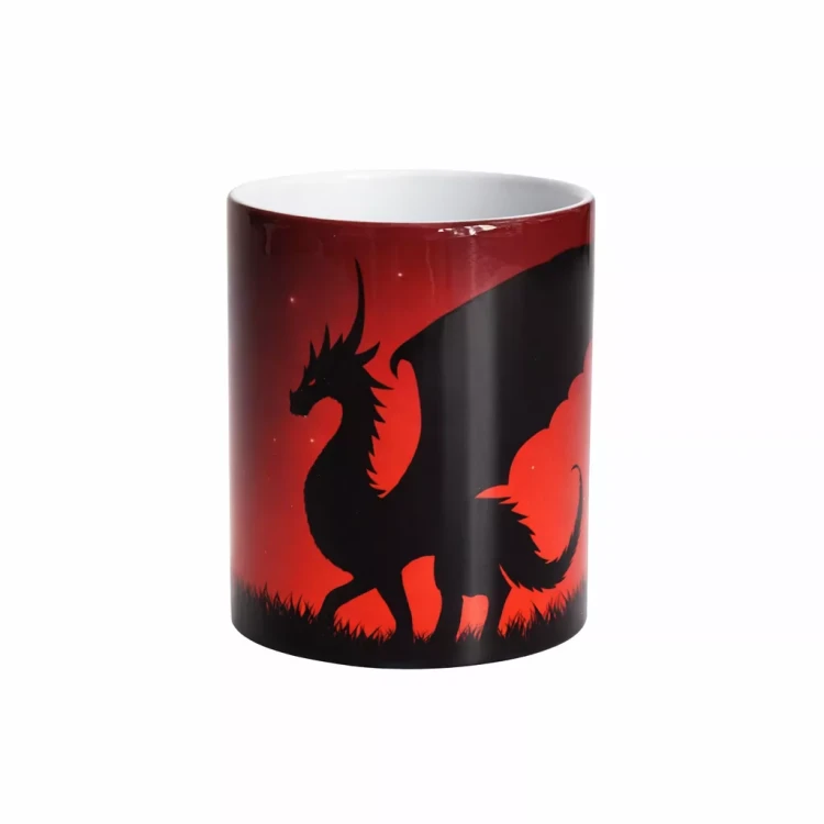 Sylwetka czarnego smoka z rozpostartymi skrzydłami na tle czerwono‑czarnego gradientu nocnego nieba, stojącego na trawie, na ceramicznym kubku.