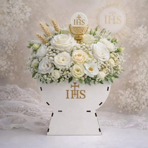 Biała kompozycja kwiatowa w kielichu z symbolem „IHS”, z różami, gipsówką i kremowymi kwiatami. Nad nimi dekoracja w formie hostii z „IHS”, złotym kielichem i kłosami. Całość jasna, miękko oświetlona, na tle koronkowej tkaniny.
