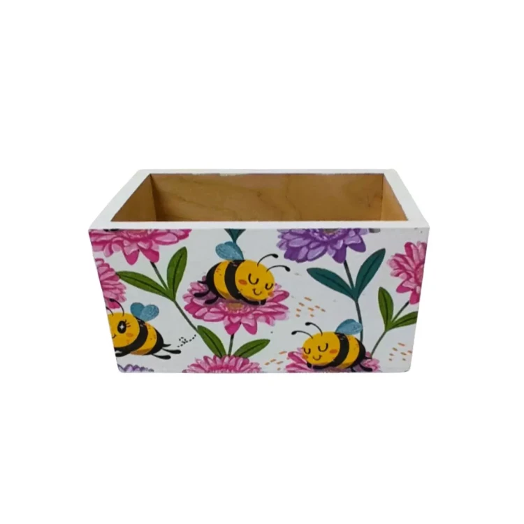 Ozdobne pudełko z drewna, prostokątne, zewnętrzne ścianki pokryte jasnym motywem pszczół i kwiatów w stylu decoupage; wnętrze gładkie, naturalne.