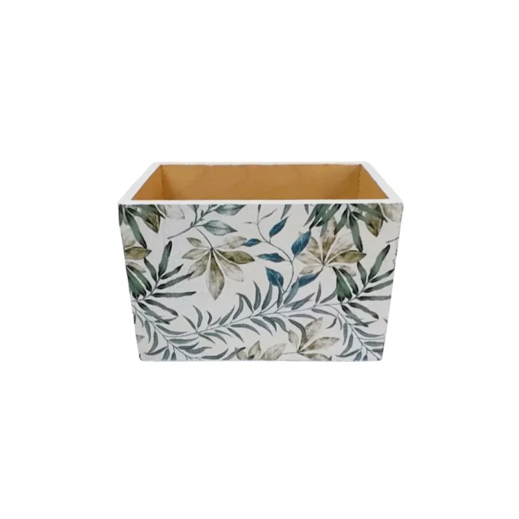 Dekoracyjne pudełko z roślinnym nadrukiem na białym tle. Liście w zieleni otaczają proste, drewniane wnętrze.
