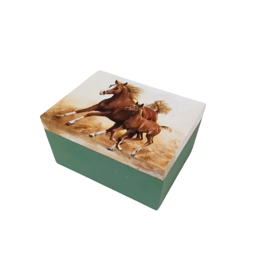 Zamknięte drewniane pudełko z zieloną podstawą i wieczkiem ozdobionym ilustracją dwóch galopujących koni. Motyw koni dynamiczny, w ciepłych barwach. Pudełko ma prostą formę i gładkie wykończenie.