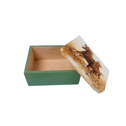 Drewniane pudełko z zieloną podstawą i wieczkiem ozdobionym ilustracją dwóch galopujących koni. Konie w ruchu, z rozwianymi grzywami. Pudełko otwarte, ukazuje naturalne drewniane wnętrze