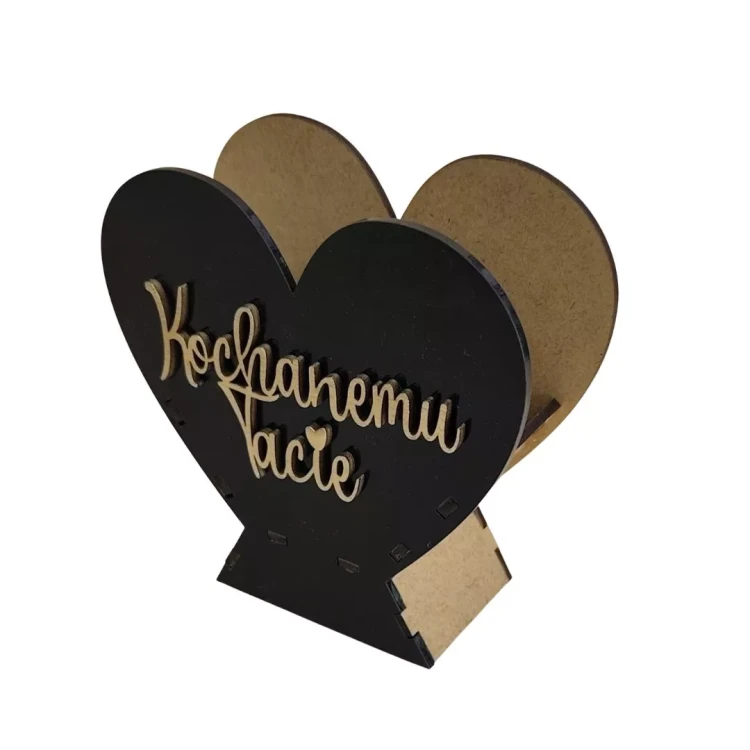 Czarne serce z drewnianą podstawą i jasnymi bokami, z przodu gładka płyta z pleksi. Na środku przyklejony złoty napis „Kochanemu Tacie” w dekoracyjnym piśmie. Elegancka, prosta ozdoba w formie prezentu dla taty.