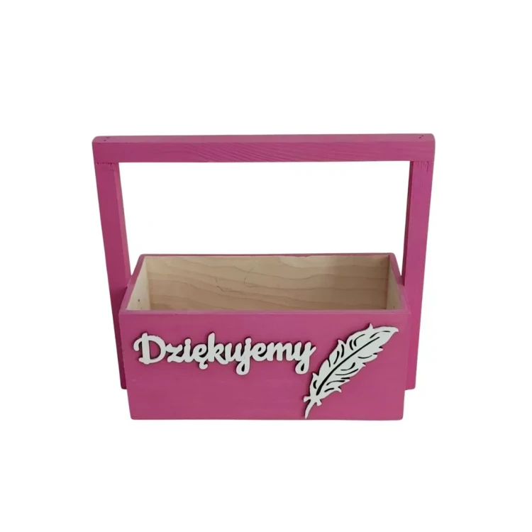 Drewniana skrzynka z rączką w kolorze różu na białym tle. Na jej przedniej ściance znajduje się wypukły, biały napis „Dziękujemy” napisany ozdobną czcionką, a obok niego ozdoba w kształcie białego pióra. Wnętrze jest jasne.