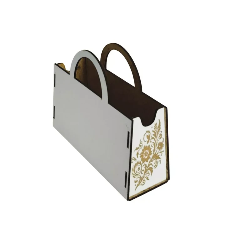 Biały flower box w kształcie torebki z uchwytami, widok z tyłu i boku. Na bocznej ściance znajduje się elegancki, złoty grawer z motywem roślinnym. Konstrukcja składana na widoczne wypustki, wnętrze i krawędzie w naturalnym kolorze drewna.