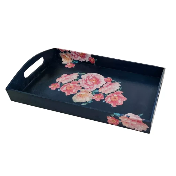 Drewniana taca decoupage z widokiem z boku. Ciemnogranatowe tło, na którym widnieje duży bukiet różowych kwiatów na środku oraz mniejsze motywy kwiatowe na rogach ścianek. Taca ma wygodne, podłużne wycięcia na dłonie.