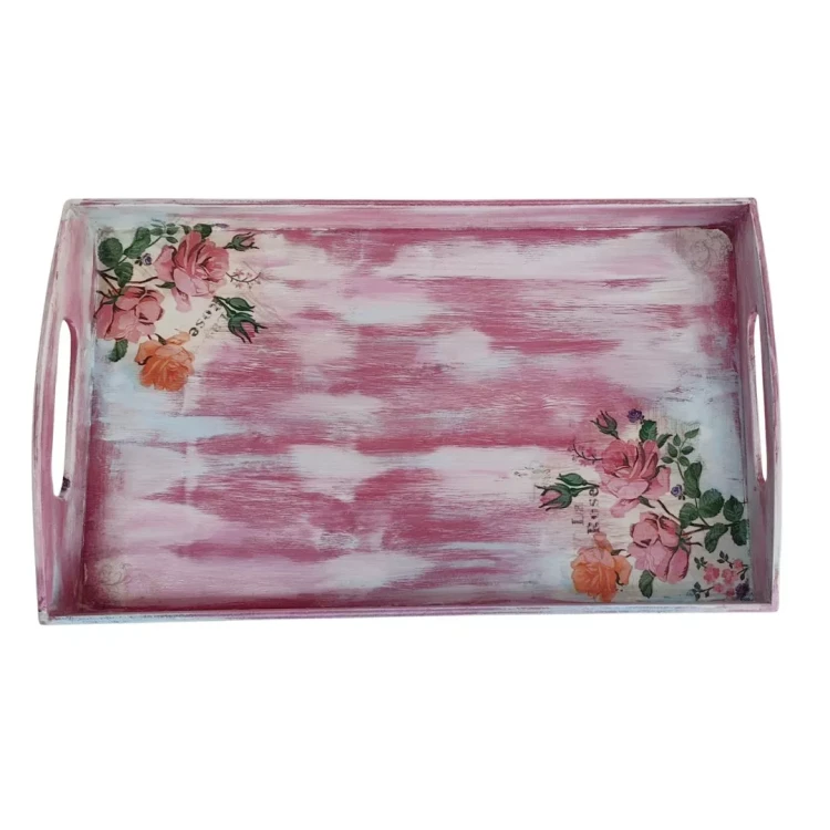 Drewniana taca decoupage w różowo-białe pasy, sfotografowana prosto z góry. W lewym górnym i prawym dolnym rogu dna tacy znajdują się ozdobne grafiki przedstawiające rozwinięte różowe i herbaciane róże z pąkami oraz zielone liście.
