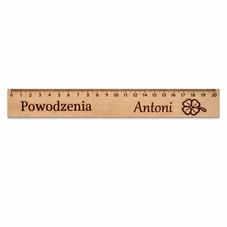 Drewniana linijka o podziałce długości 20 cm z wygrawerowanym napisem „Powodzenia Antoni” i symbolem czterolistnej koniczyny. Wykonana z jasnego drewna, ma precyzyjną podziałkę w centymetrach i milimetrach. Jest praktyczna i ozdobna.