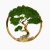 Okrągła dekoracja ścienna przedstawiająca drzewo bonsai wykonane z zielonego mchu. Skręcony pień i gałęzie z opalanego drewna tworzą naturalny wzór wewnątrz drewnianej obręczy, nadając kompozycji spokojny, inspirowany naturą charakter.